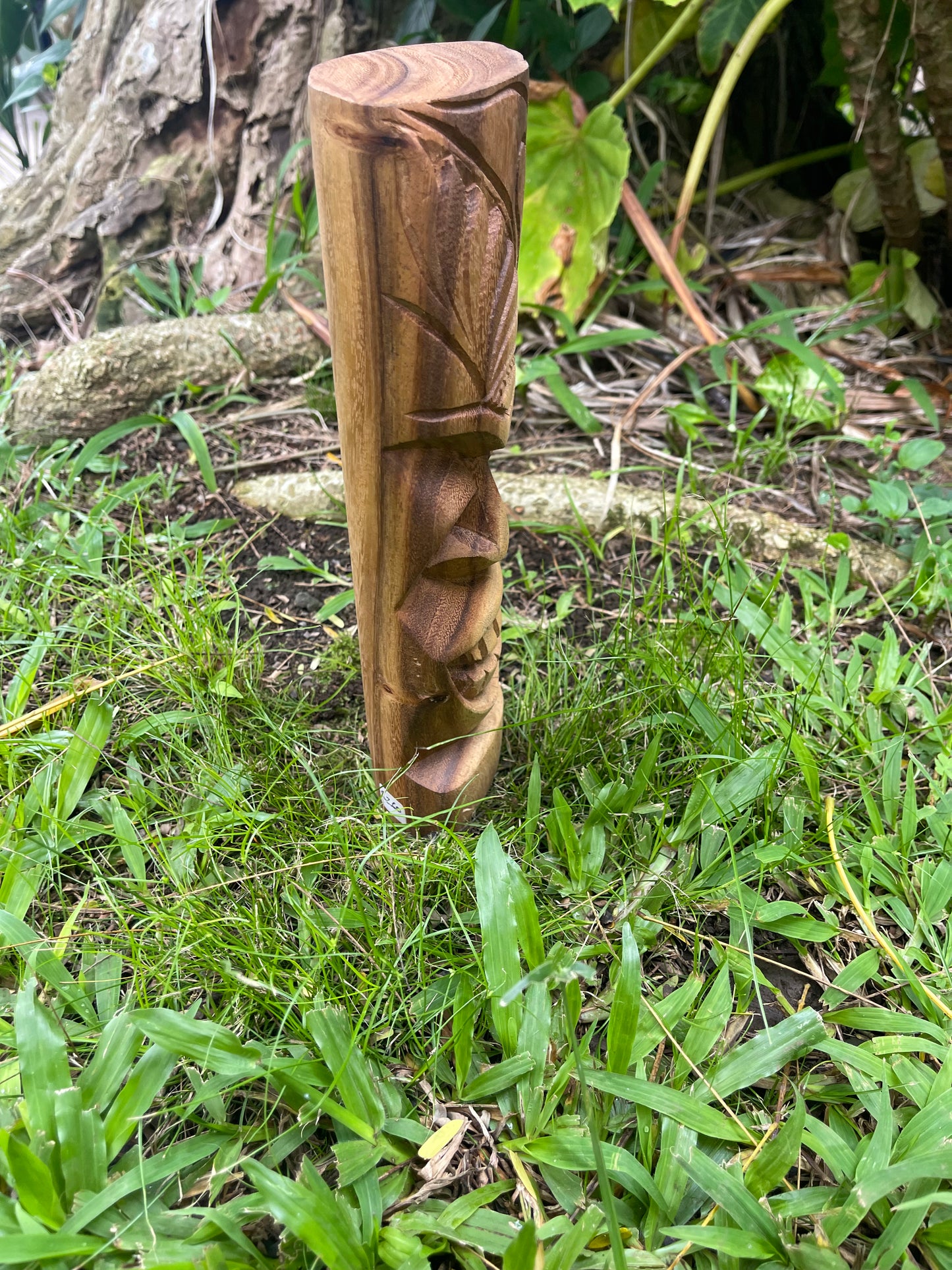 Side View of Smiling Tiki with Wave and Island Designs