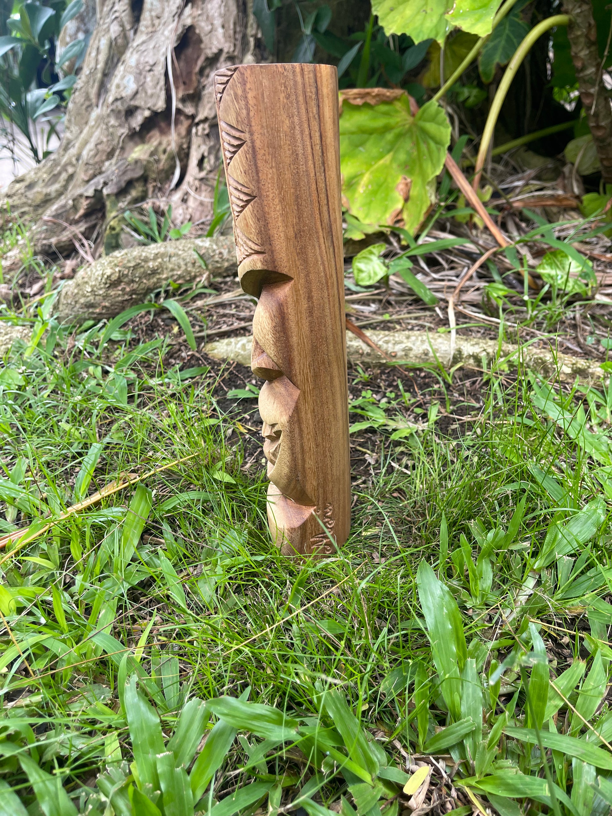 Side View of Smiling Tiki with Wave and Island Designs